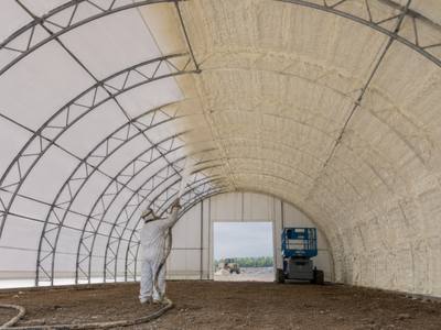 Fabric arch building sprayed along the roof line