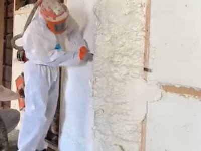 Foam being trimmed back flush to the framing