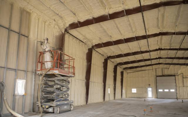 Large commercial building sprayed section by section from a lift